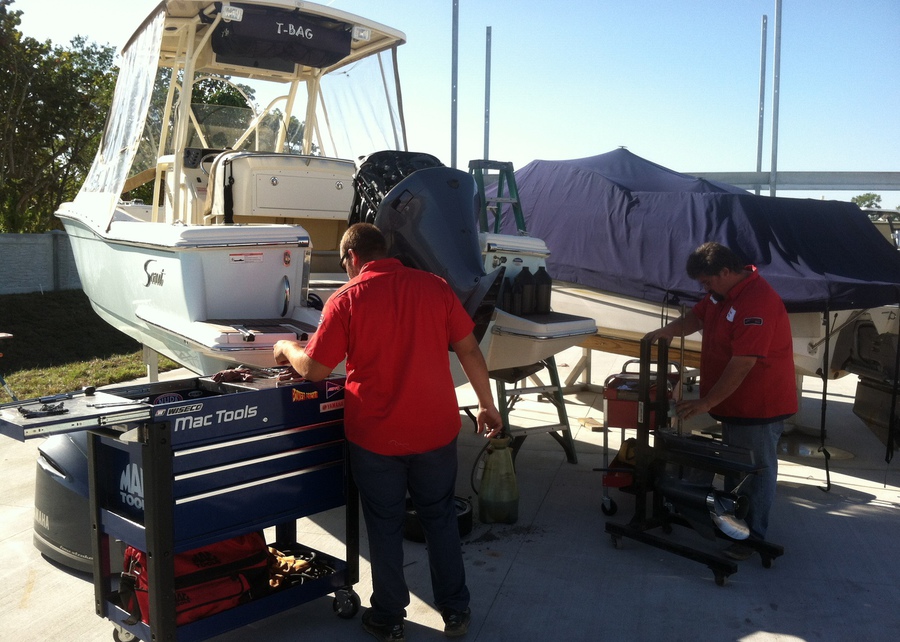 Two Everest Marina technicians servicing a center-console boat